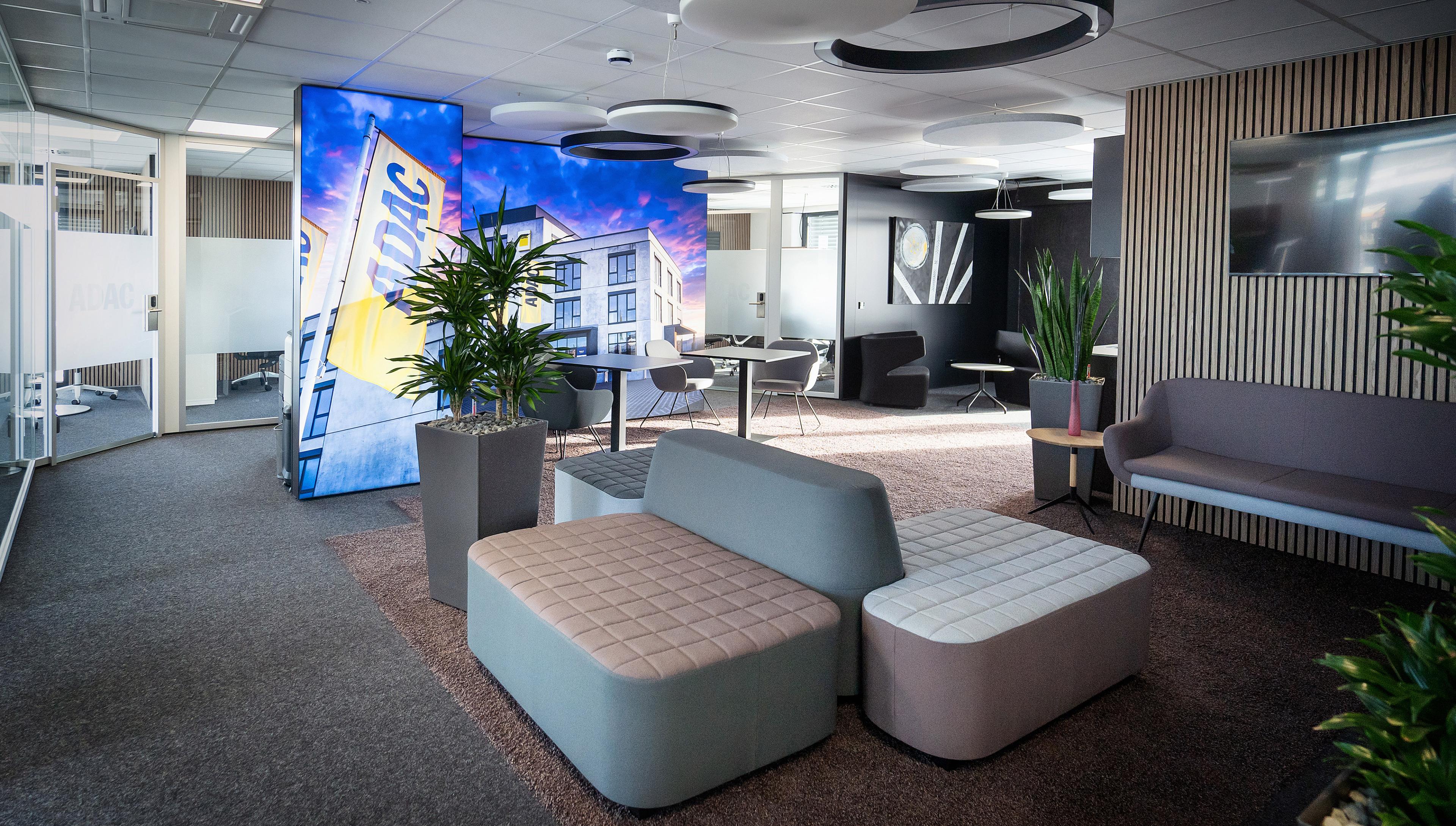Bild von einer offenen Büro Umgebung mit Sofas und einer Lichtwand