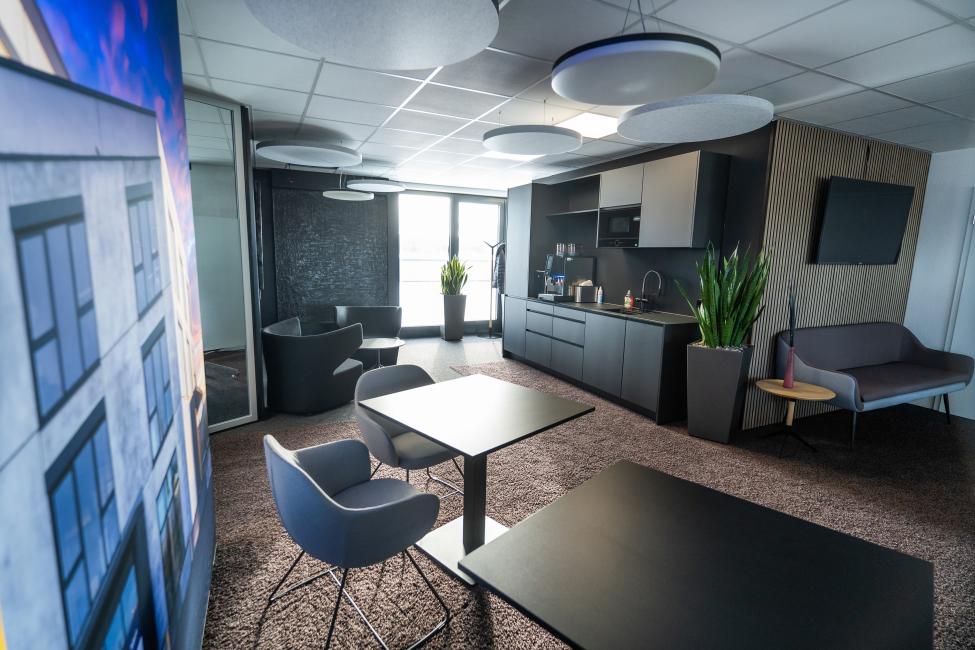 Modernes Büro mit einer Küche und einem Essbereich, der eine einladende Arbeitsatmosphäre schafft.